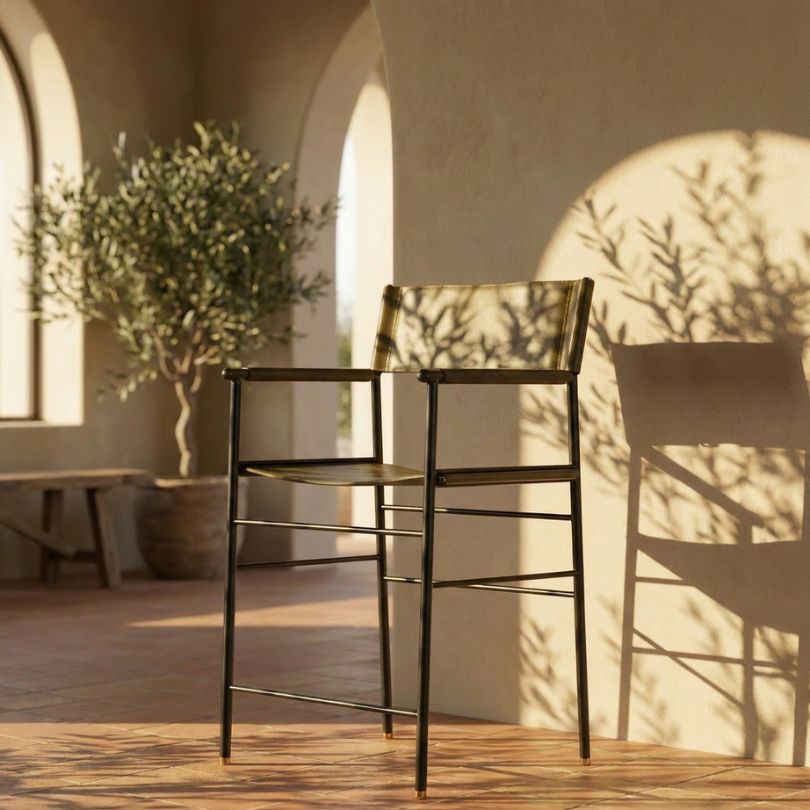 Bar stool with olive green leather and black metal frame with brass details in a Mediterranean interior